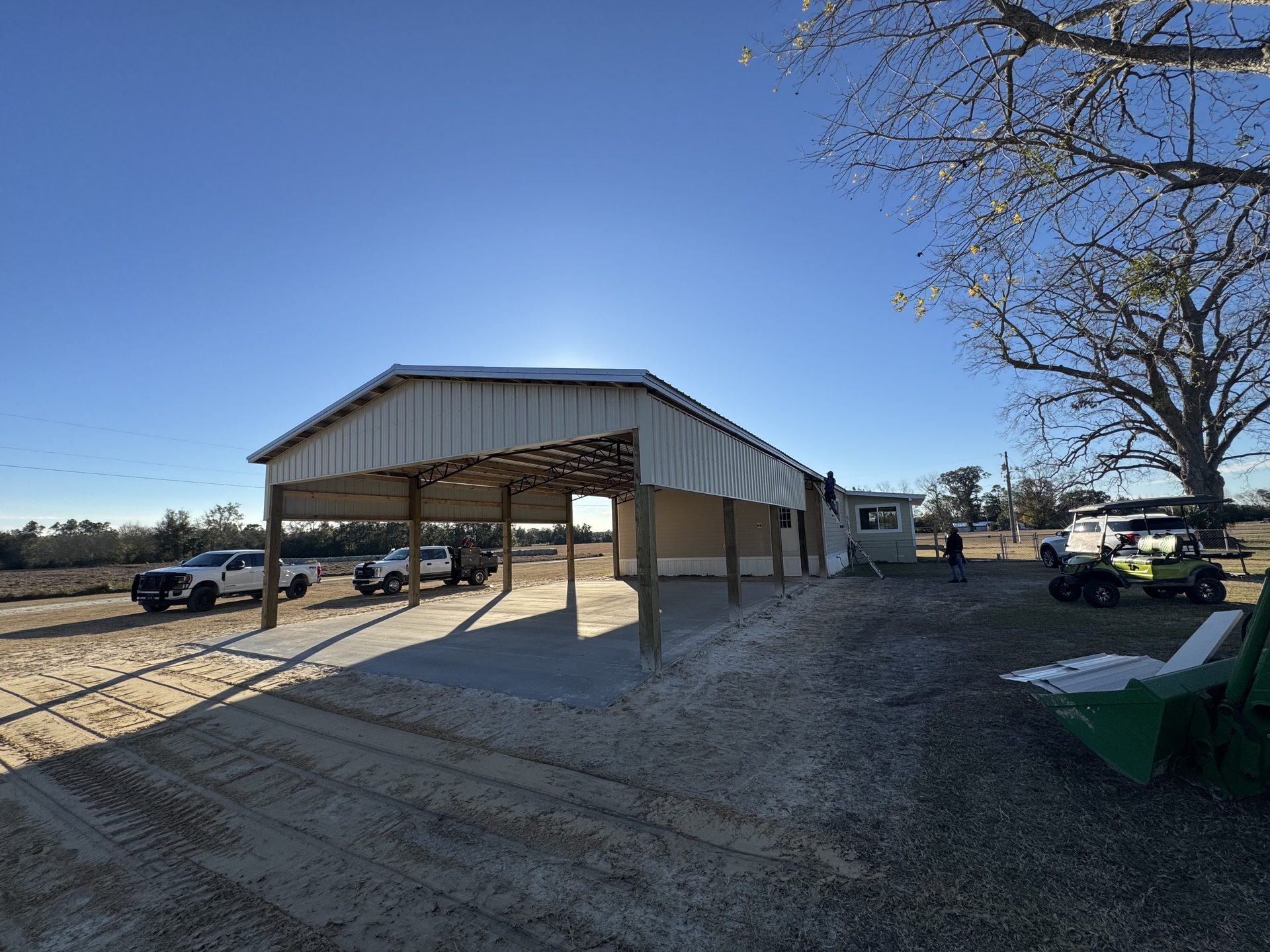 Completed pole barn structure with metal roofing on a clear day