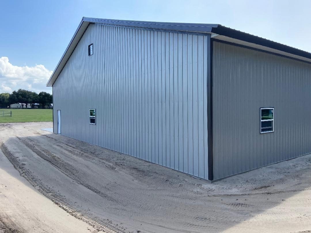 Pole barn with roll-up garage doors on a cleared rural lot