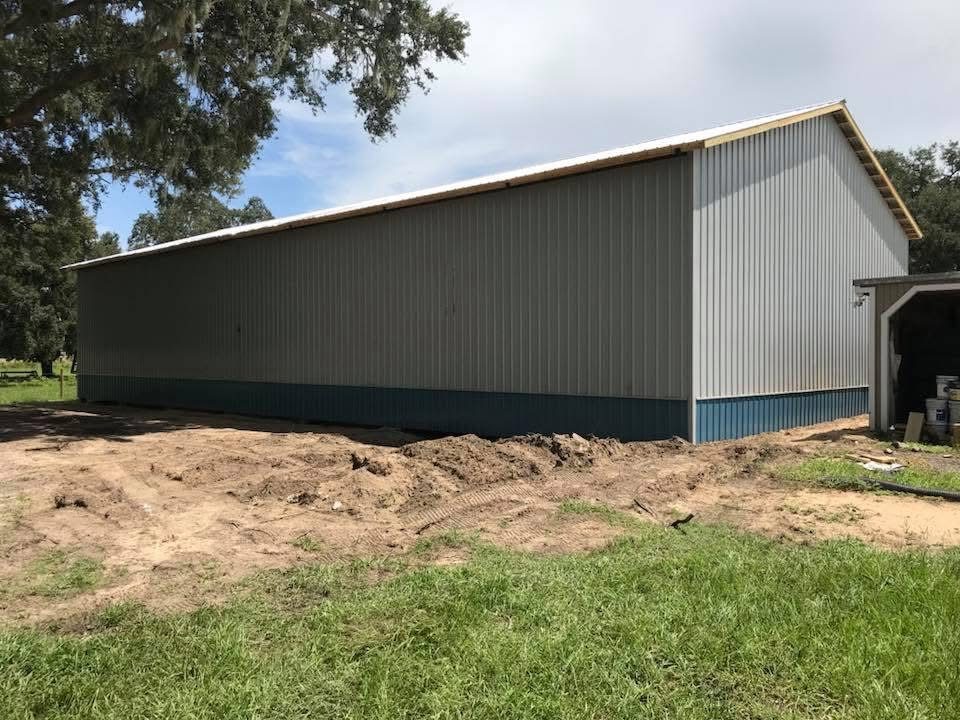 Side view of completed pole barn with metal roof and treated posts