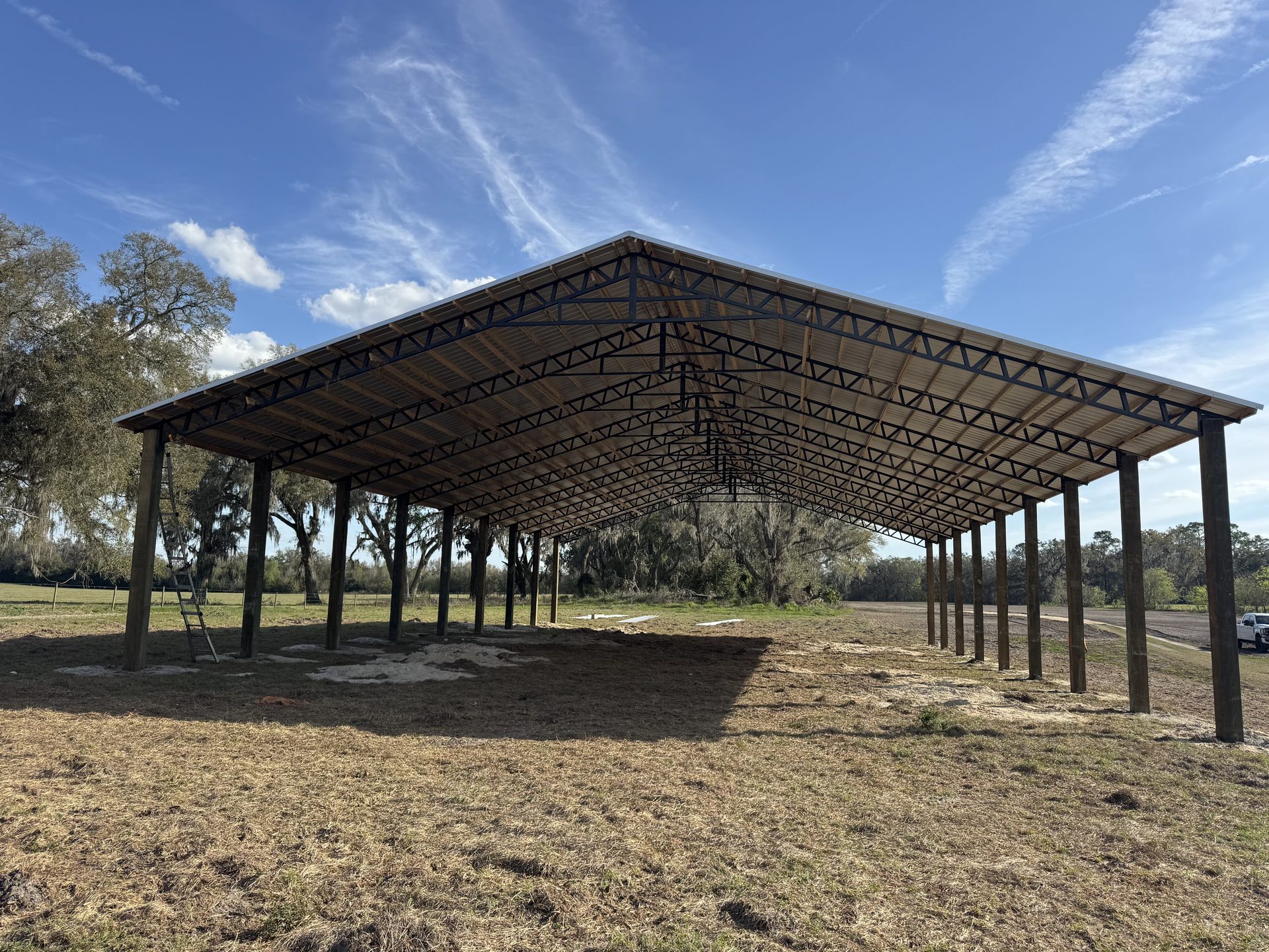 Completed barndominium with covered front porch and wood post accents