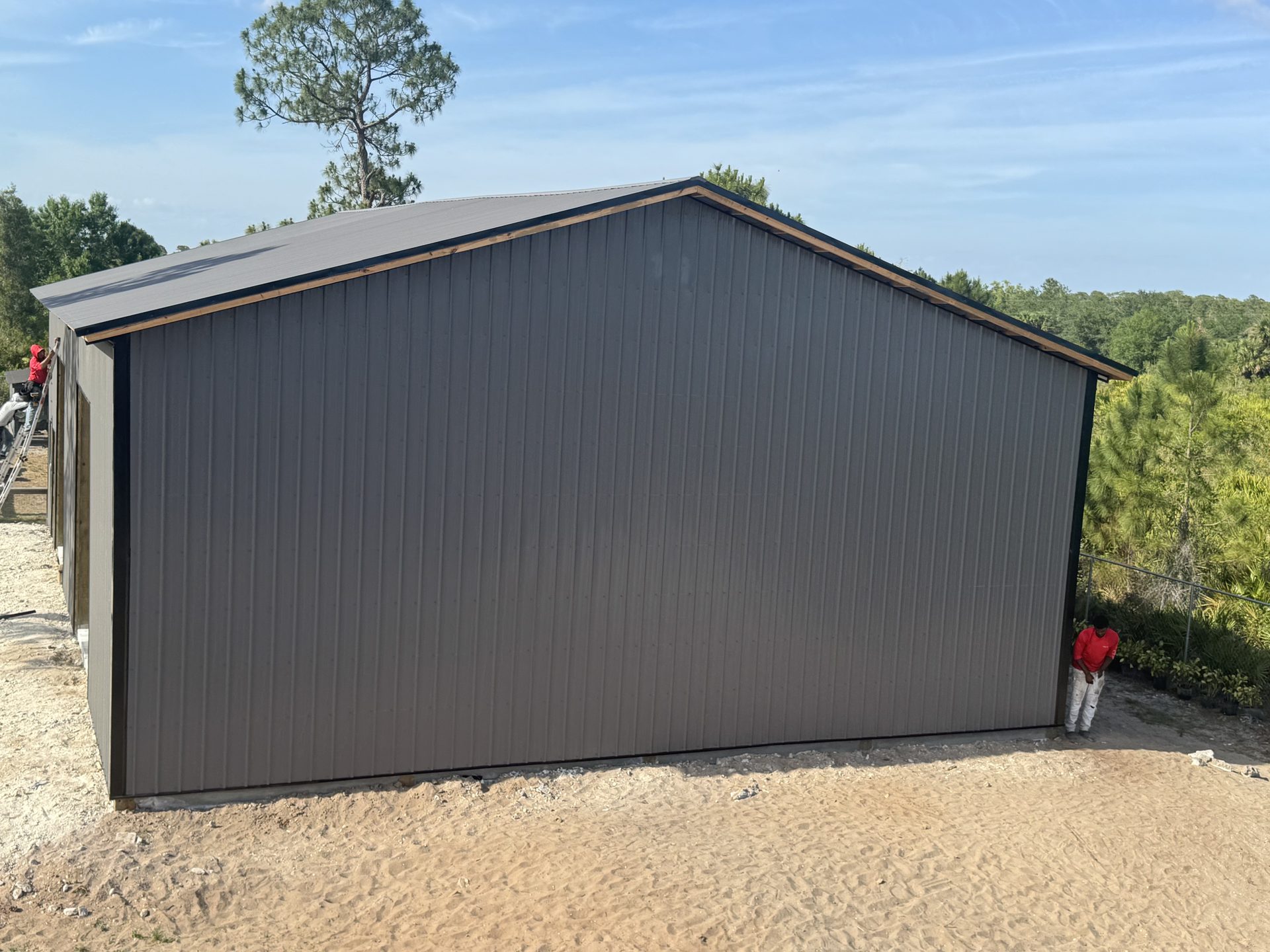 Black enclosed barndominium exterior — side angle view