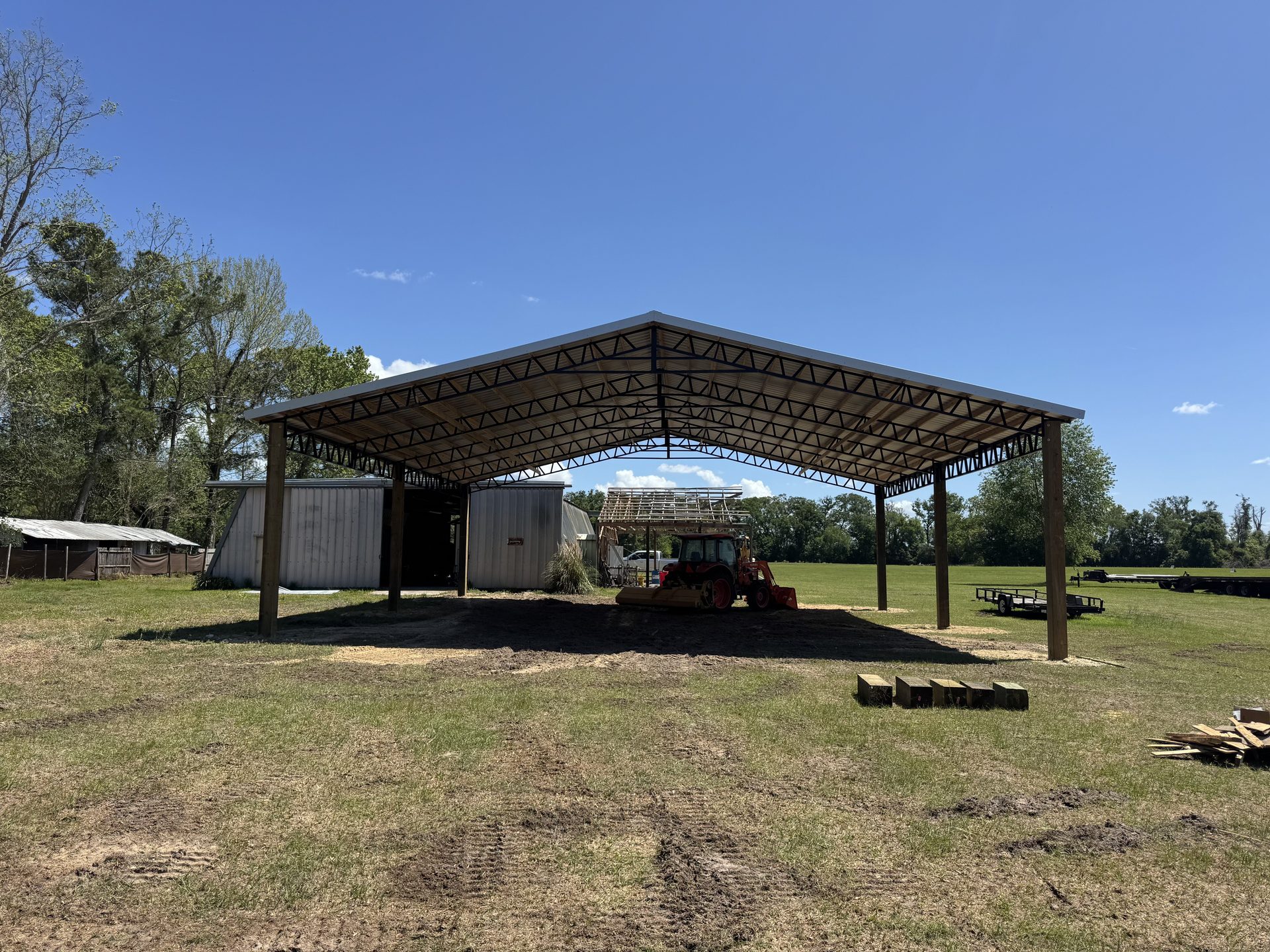 Pole barn exterior with open bay and treated post framing