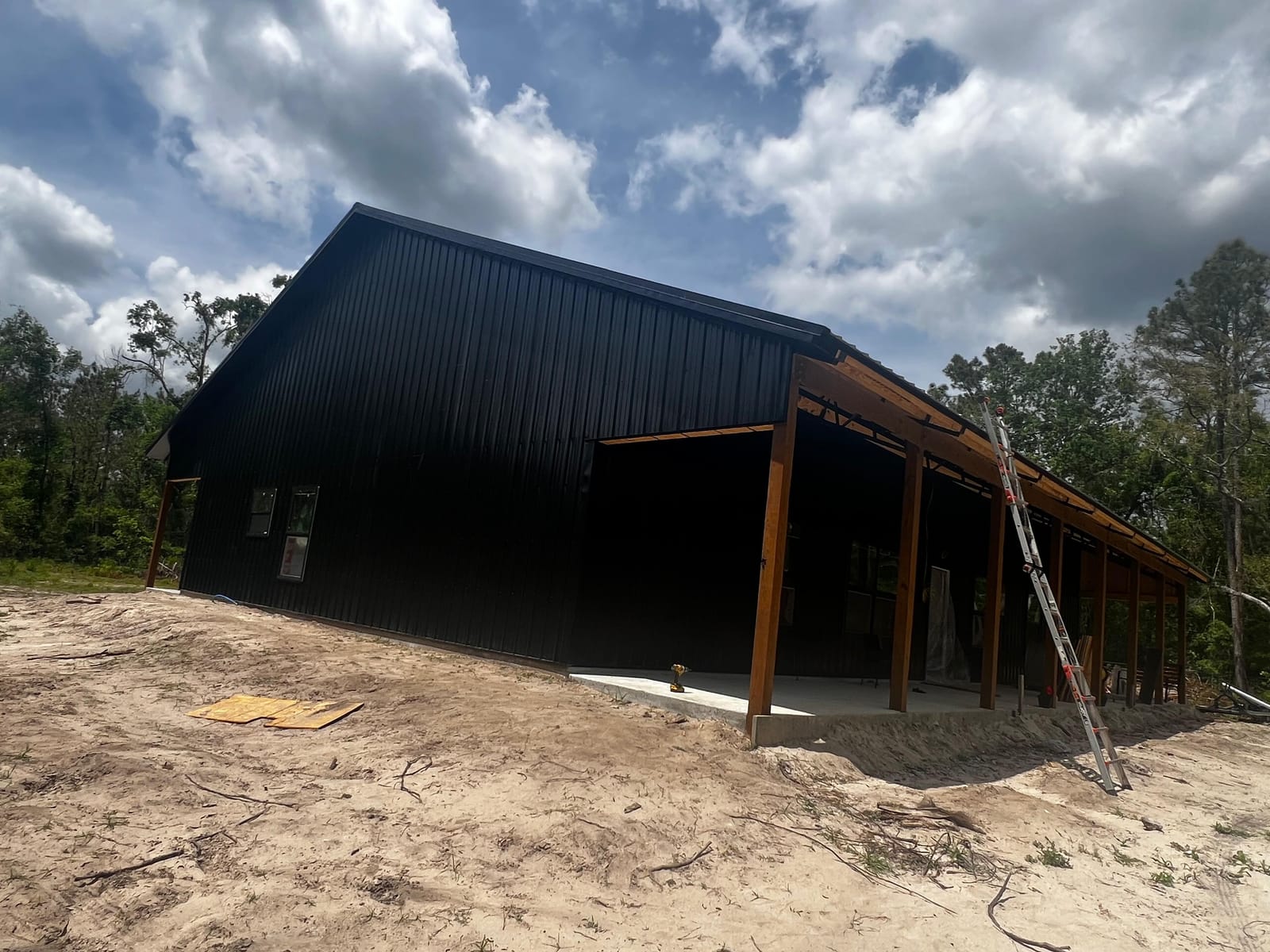 Enclosed Pole Barns — Black barn with open lean-to