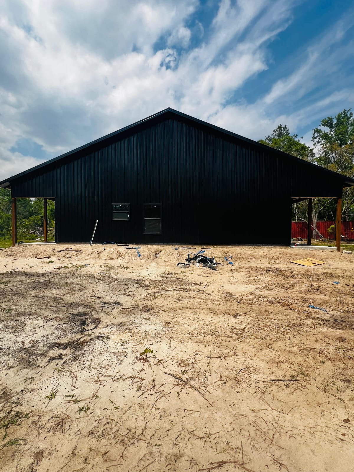 Enclosed Pole Barns — Black gabled barn with windows